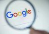 Google logo viewed through a magnifying glass