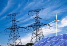 Solar panels and a wind turbine with power lines against a blue sky