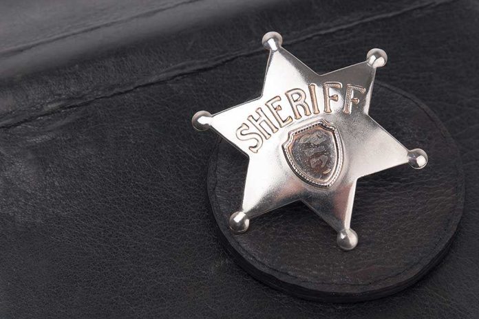 shutterstock_189922118.jpg A silver sheriff badge resting on a black leather surface