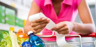 Person examining a receipt while shopping for groceries