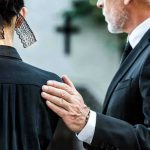 Man comforting woman at funeral service.