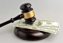 Gavel resting on hundred-dollar bills.