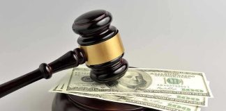 Gavel resting on hundred-dollar bills.