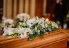 Flower arrangement on a wooden casket at a funeral.
