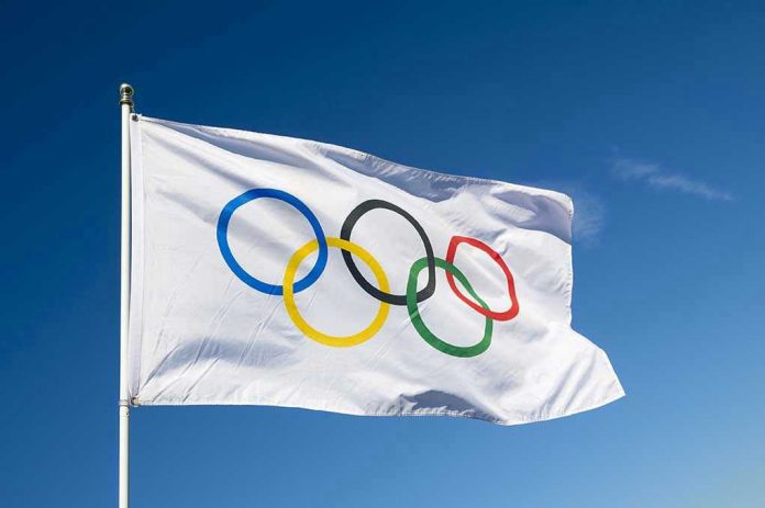 430080421 Olympic flag waving against clear blue sky