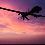 Silhouette of a drone against a colorful sunset