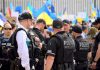 Police officers gathered near a crowd with flags.