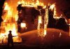 A firefighter battling a large house fire at night