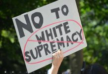 Nazi Uniform ATTACK—Vicious Assault! Sign saying No to white supremacy with red circle.