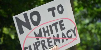 Sign saying No to white supremacy with red circle.