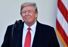 Trump Offers Mamdani Olive Branch – What’s His Game? Man in suit and tie speaking at podium.