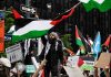Palestine Protesters FLOOD Store – Black Friday CHAOS! Protesters with flags and signs, one holding a megaphone.