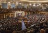 Large assembly in a government legislative chamber.