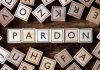Trump FREES Billion-Dollar Scammer After Two Weeks Wooden letter blocks arranged to spell 'PARDON' on a wooden surface