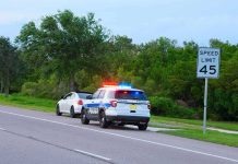 Driver FLEES Cops – Kills 4 Bystanders Police car with flashing lights pulling over a white vehicle beside a speed limit sign