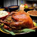 SHOCKING Benefits of “Bad” Thanksgiving Foods A beautifully roasted turkey on a festive table surrounded by side dishes and decorations
