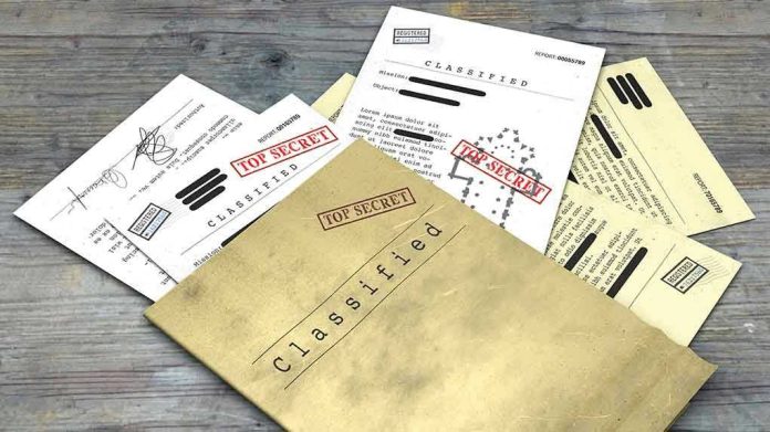 1099529729 Classified documents with Top Secret stamps on wooden surface.