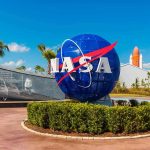 Billionaire’s NASA Takeover: Moon Race On! NASA logo sculpture with spaceship and palm trees.