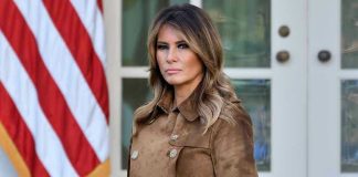 Trump’s Ukraine Deal IMPLODES – Melania Steps In Woman in brown coat beside American flag.