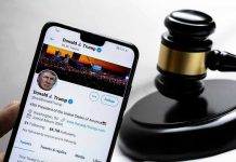 Trump’s Bold Move — Will He Defy Supreme Court? Smartphone displaying Twitter profile near a judges gavel.
