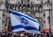 Israeli flag at a crowded outdoor event.