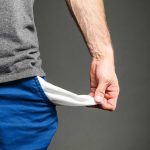 Person pulling out empty pocket from shorts.