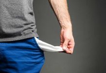 Six-Figure “Poverty” Claim Sparks Outrage Person pulling out empty pocket from shorts.