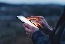 Person using a smartphone at dusk.