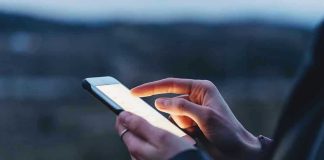 Person using a smartphone at dusk.