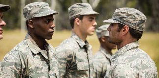 Military personnel standing in line outside during inspection.