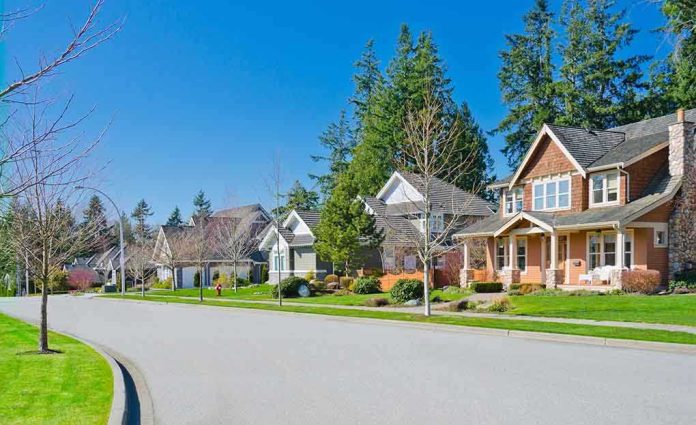 shutterstock_109612322.jpg A sunny suburban neighborhood with houses and green lawns