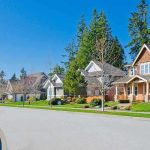 A sunny suburban neighborhood with houses and green lawns