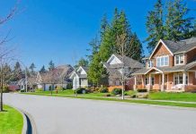 Airbnb Owners ALERT: Squatter Threats Rise A sunny suburban neighborhood with houses and green lawns