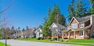 A sunny suburban neighborhood with houses and green lawns