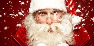 Santa Claus blowing snowflakes with a joyful expression