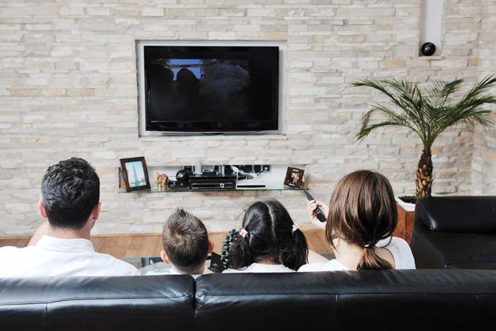 shutterstock_79170475.jpg A family of four watching television together in a cozy living room