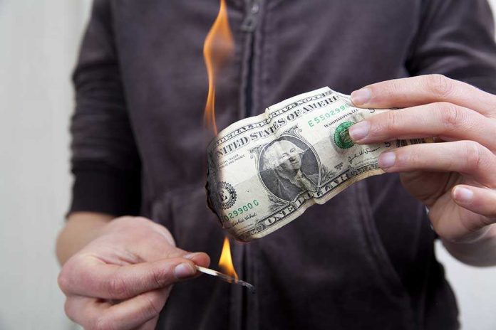 A person holding a burning dollar bill with a match in the other hand