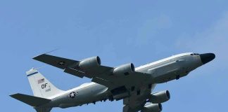 Military aircraft flying in clear blue sky.