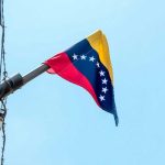 US Strikes Overthrow Maduro: What’s Next for Venezuela? Venezuelan flag flying on a pole.