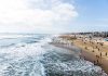 HORRIFYING: Severed Heads Found on Tourist Beach Crowded beach with waves and people enjoying sun.