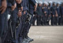 Line of police officers in uniform in formation.