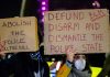 Crisis Looms: Anti-Police Rage Erupts Two individuals holding protest signs with messages about police reform
