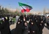 Iran’s President’s SHOCKING TV Appearance Amid Chaos Group of women in black attire marching with an Iranian flag