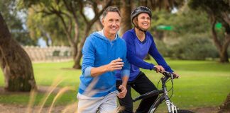 A couple enjoying outdoor exercise, with one riding a bike and the other jogging alongside