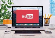 YouTube logo on a laptop screen on desk.