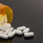 Chronic Pain Patients Falsely Branded “Addicts” Spilled prescription bottle with white pills.