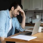 Workplace Happiness: We’ve Measured Wrong Man stressing over work on laptop at kitchen table.