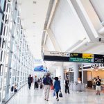 People walking in a brightly lit airport terminal.