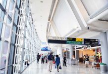 People walking in a brightly lit airport terminal.
