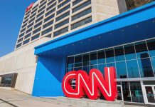 Exterior view of the CNN headquarters with a large red logo and blue entrance